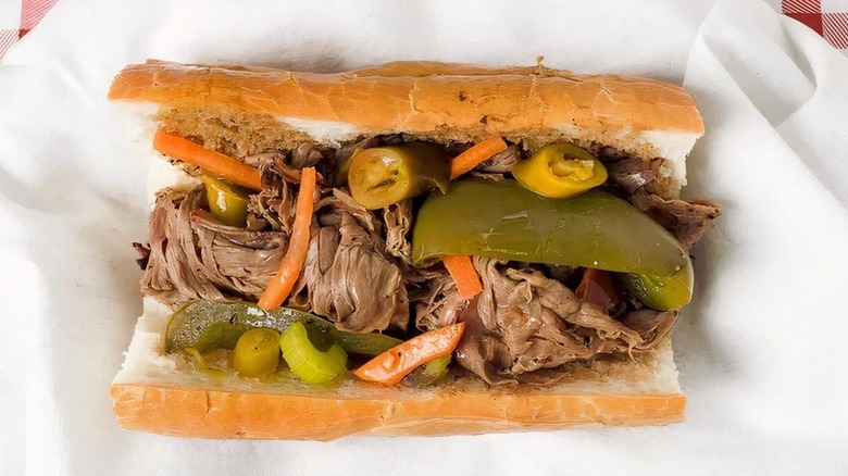 An Italian beef sandwich sits in paper wrapping.