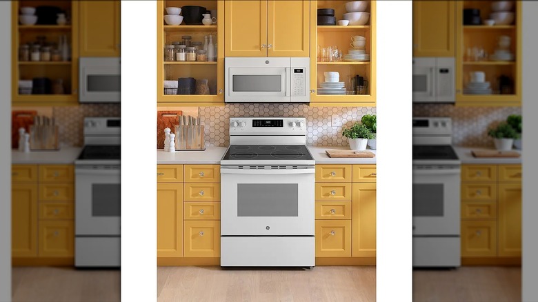 A GE electric convention range between yellow kitchen cabinets