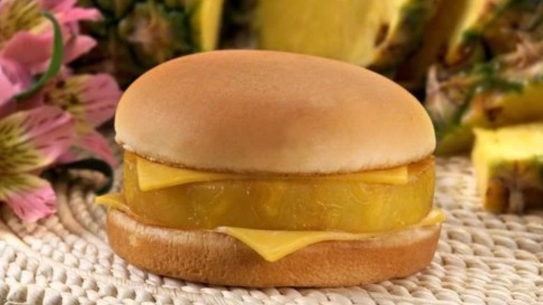 A Hula Burger with pineapple between two slices of American cheese and the halves of a bun