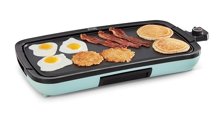 Dash Everyday Griddle in aqua with eggs, bacon, pancakes, and hashbrowns on top