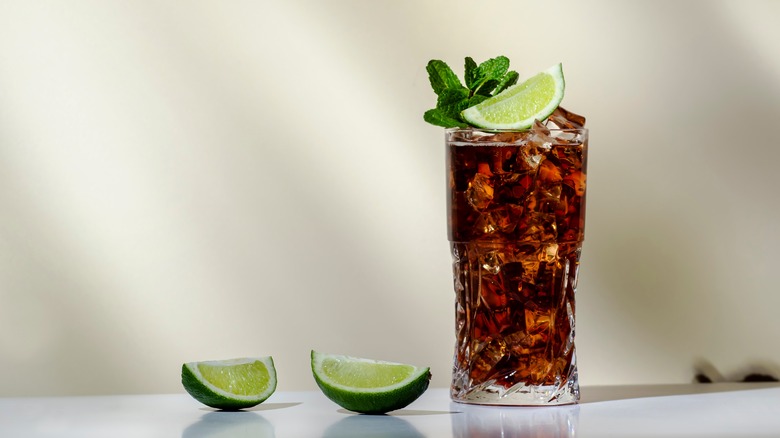 Tequila cola drink with limes