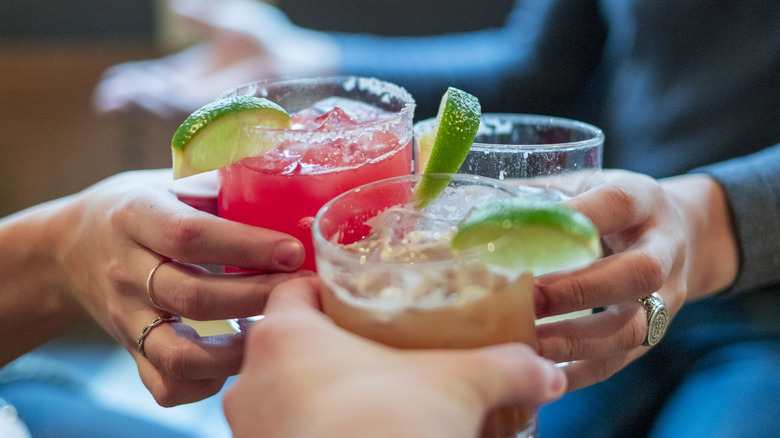 Three people toasting with margaritas