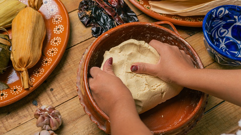 Person mixing tamale dough