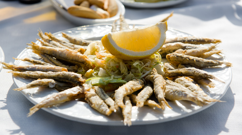 A plate of deep-fried anchovies with lemon