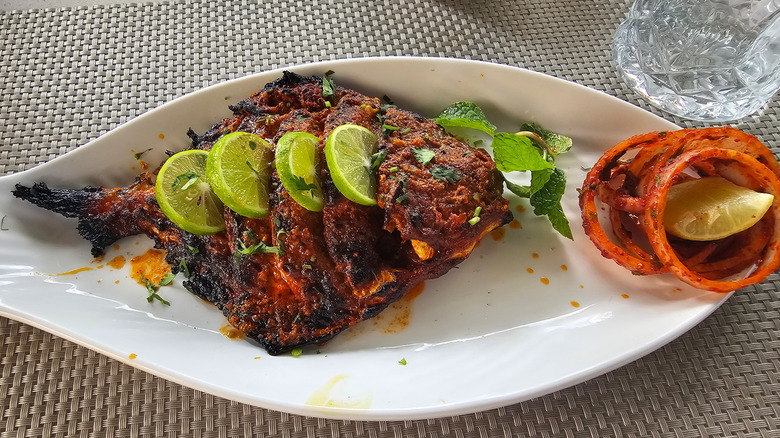 Fried monchong (pomfret) fish garnished with limes