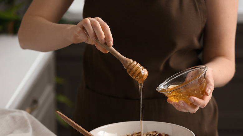 Woman adding honey to mixture 