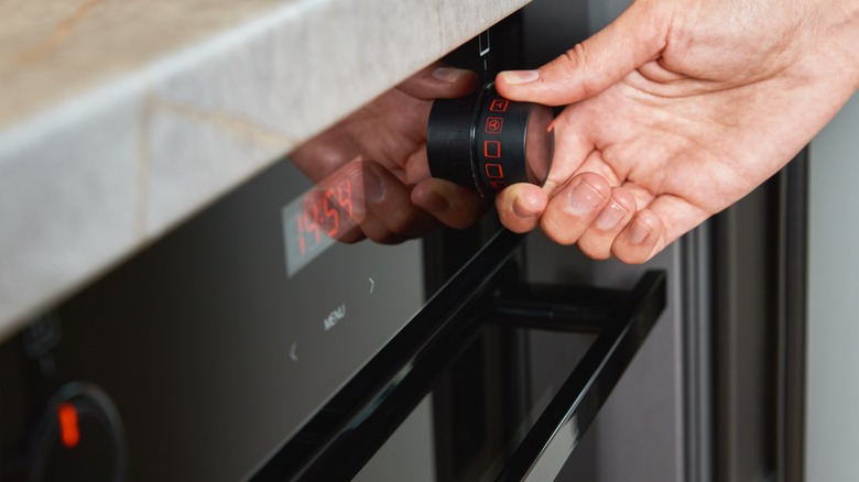 hand adjusting oven temperature