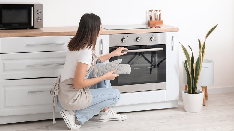 woman bending at oven