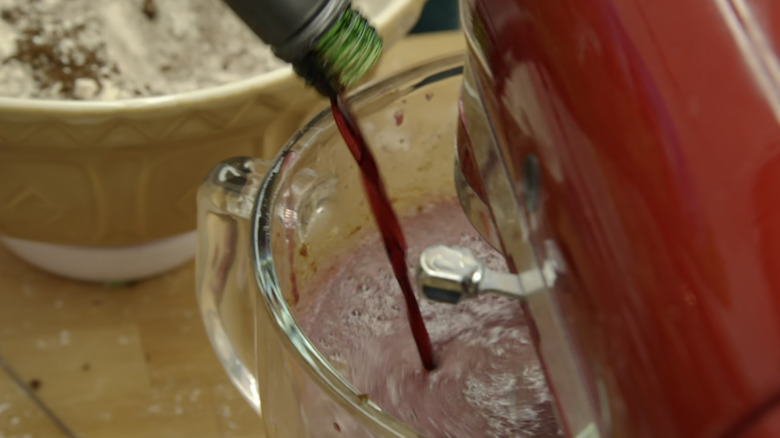 Flo adding bottle of red wine to cake batter