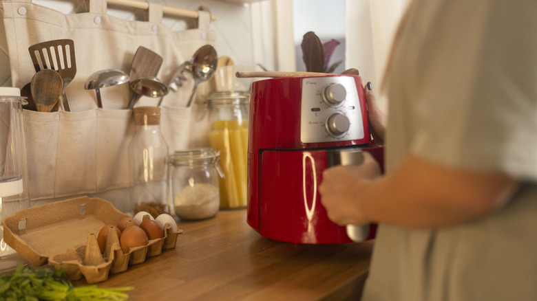 Person using a red air fryer