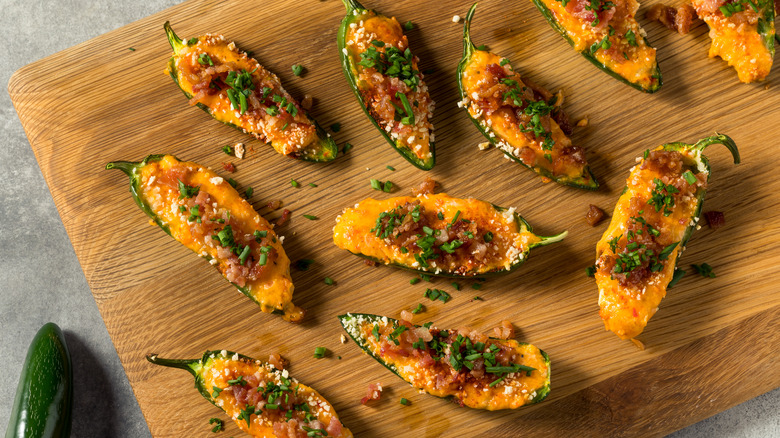 Jalapeño pepper poppers on a wooden cutting board