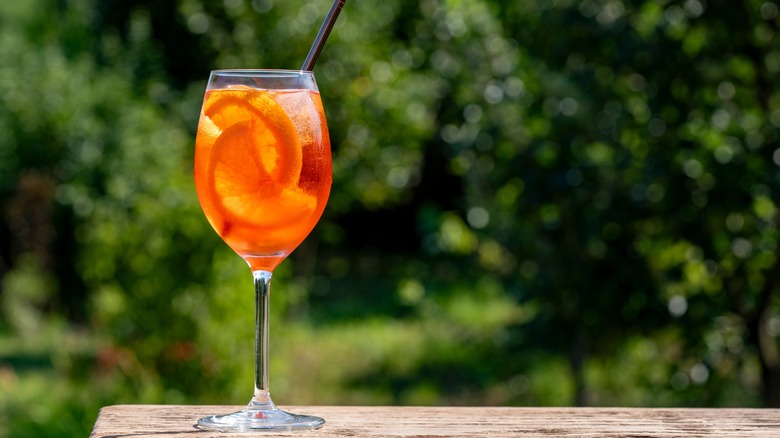 Aperol Spritz outside on table with trees in background