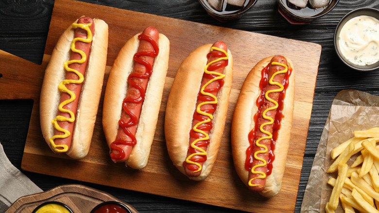 Wooden tray with ketchup- and mustard-covered hot dogs