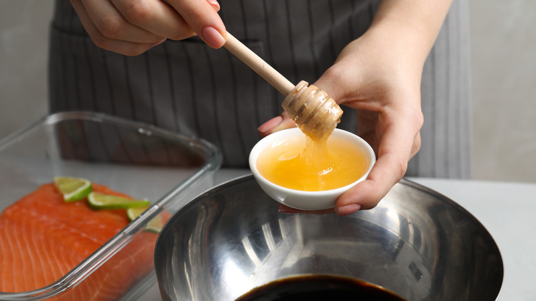 Chef assembling salmon marinade with honey and soy sauce