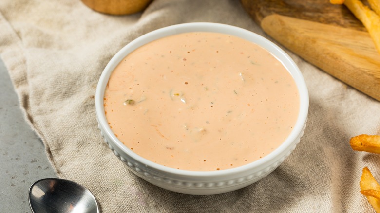 A white bowl of a light red creamy sauce