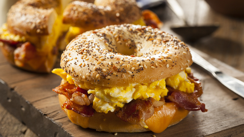 Egg, cheese and bacon bagel sandwich on a cutting board