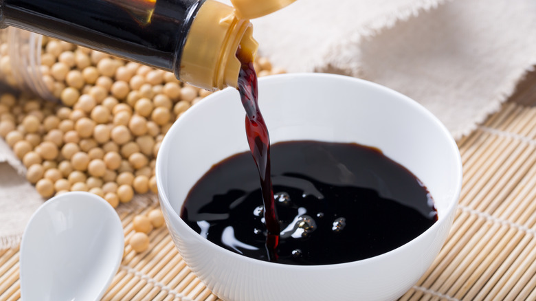 soy sauce being poured in a bowl