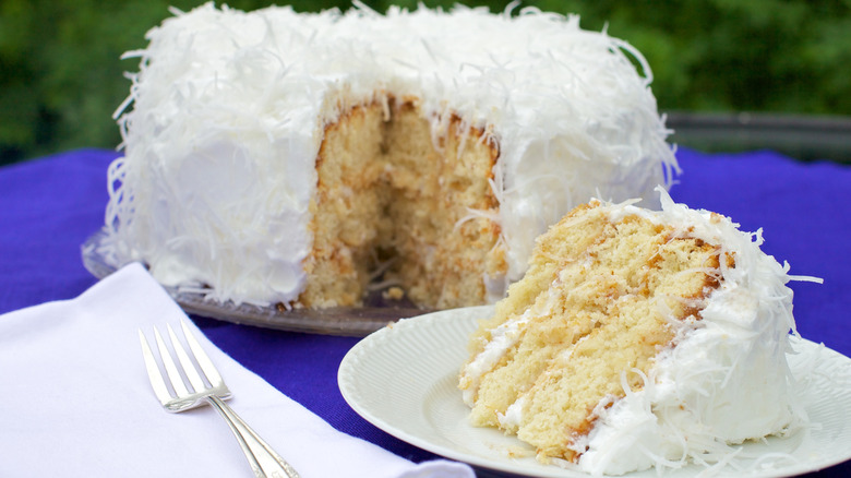 coconut cake with a slice on a plate