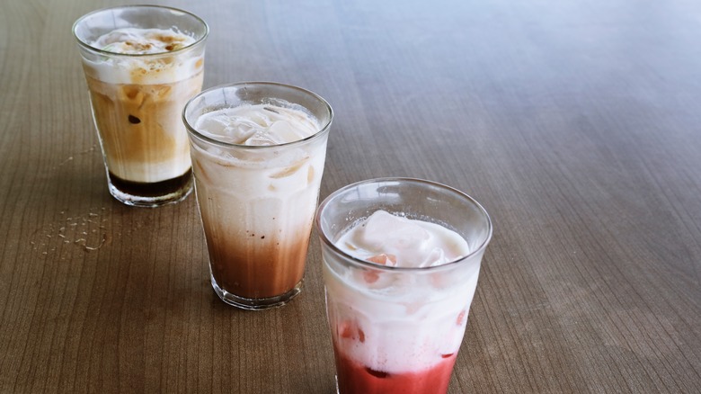 three different iced beverages topped with cold foam