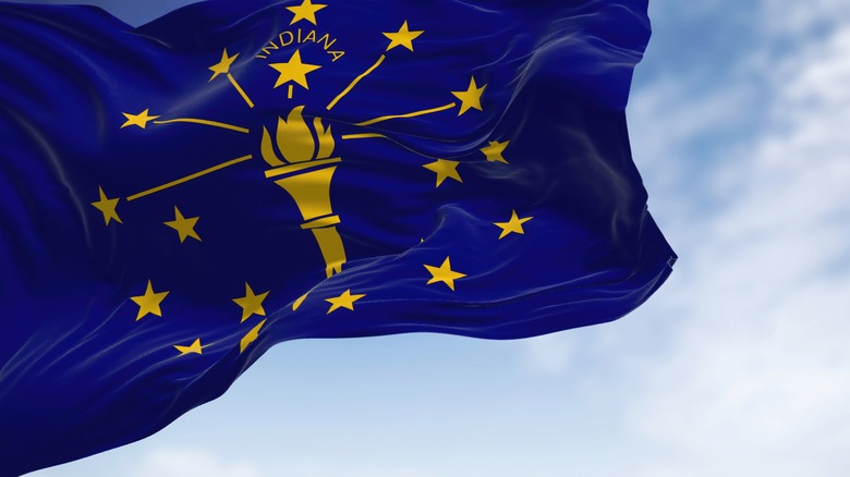 Indiana state flag with sky behind it