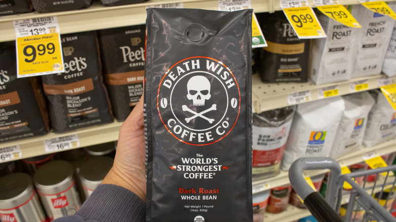 Hand holding a bag of Death Wish dark roast coffee