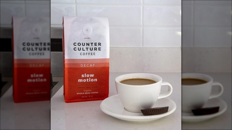 Bag of Counter Culture's Slow Motion Decaf beans in a bag alongside cup of coffee