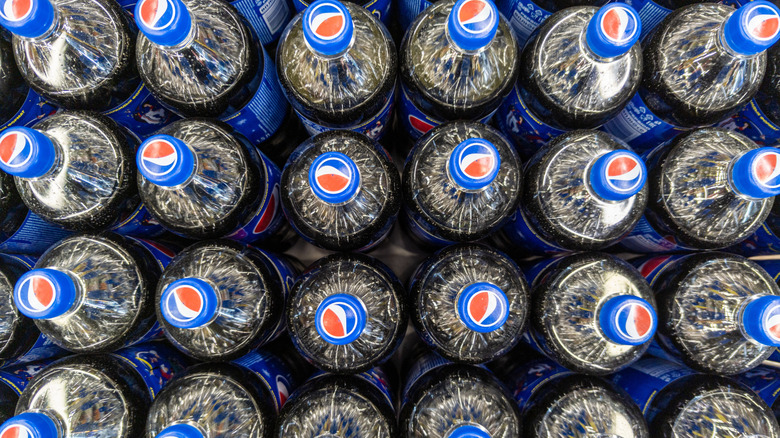 A pallet of Pepsi bottles seen from above, their bottle caps prominently visible