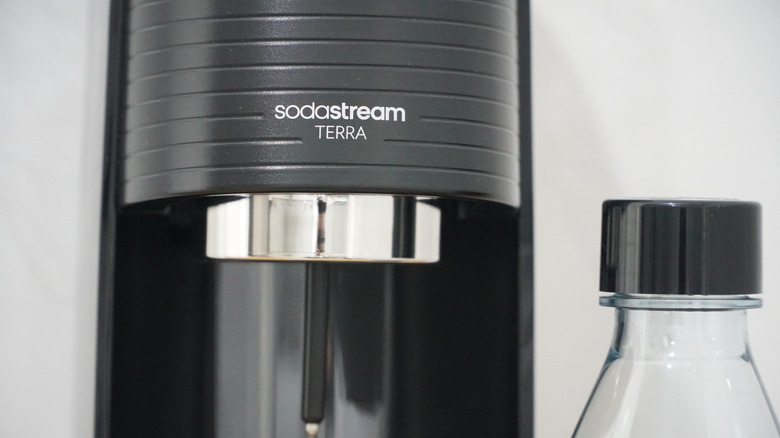 Closeup of a Terra model SodaStream soda maker and a bottle beside it