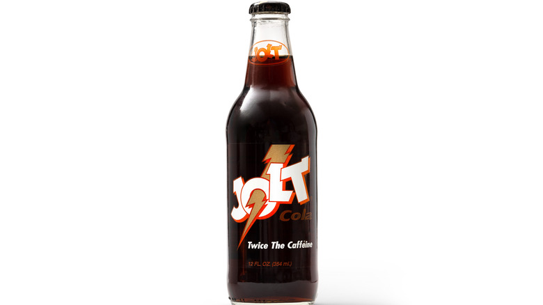 Glass bottle of Jolt Cola against a white background. The phrase "Twice the Caffeine" features prominently on the bottle