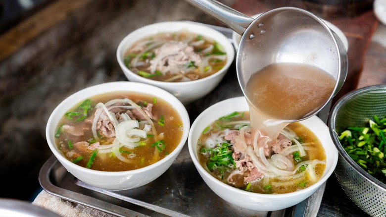 Hot broth added to pho