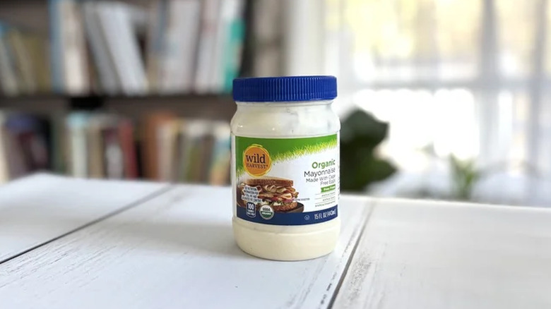 A jar of Wild Harvest mayonnaise on a wooden counter.