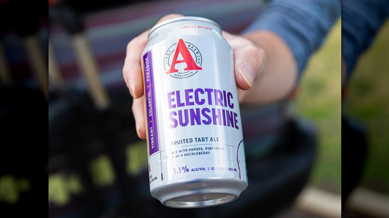 A man's hand holding a can of Avery Brewing Company beer