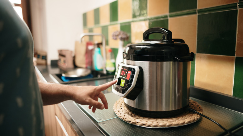 Person programming a slow cooker
