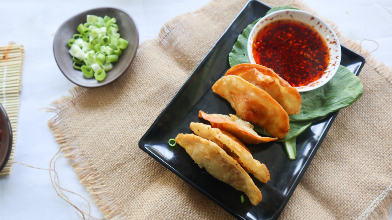 Fried wontons on plate with chili oil