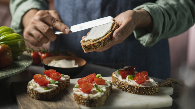 Person making open faced sandwiches