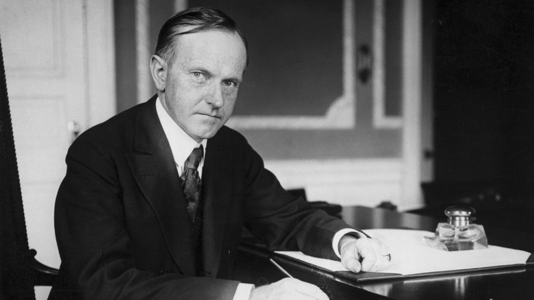 Former president Calvin Coolidge at a desk