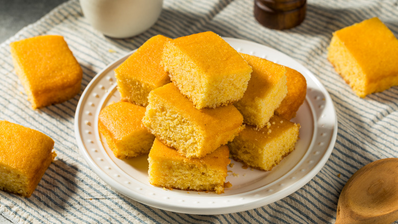 A plate of cornbread on a striped tablecloth