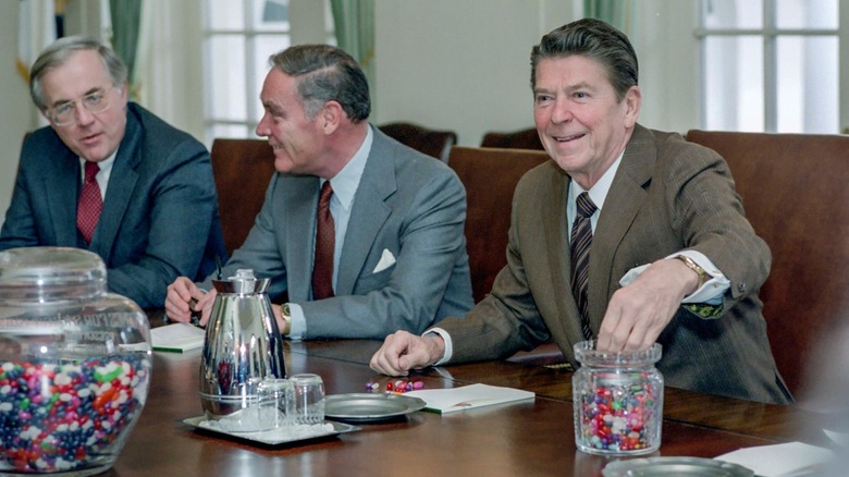 Ronald Reagan smiles while picking jelly beans from jar