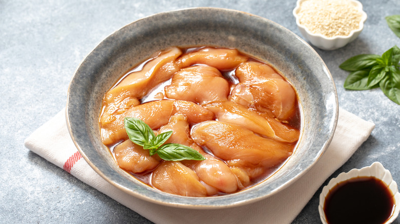 Raw chicken breast filets marinating in a bowl