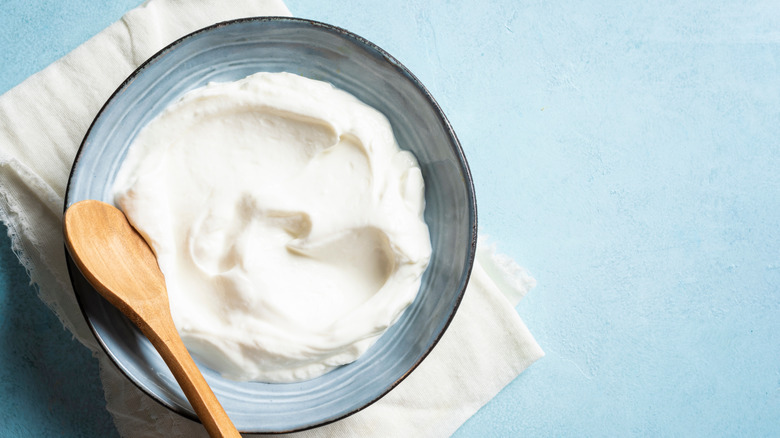 Bowl of sour cream with wooden spoon