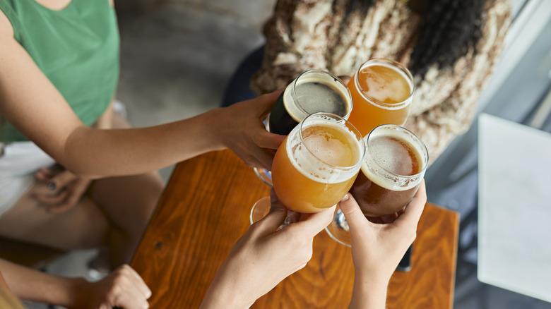 Hands clinking beer glasses