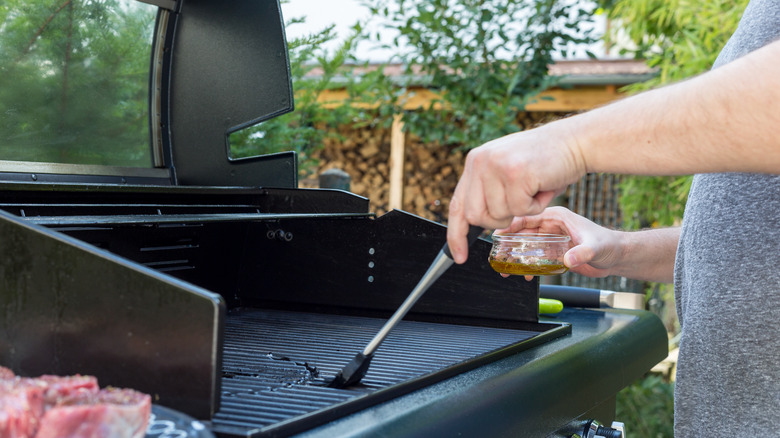 Man putting oil on grill