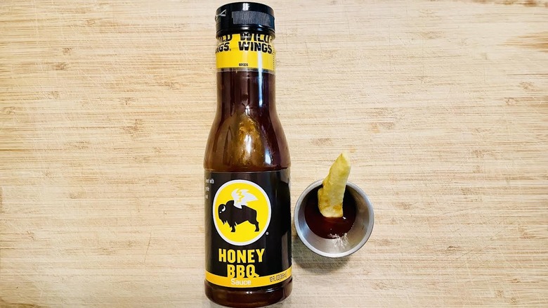 Bottle of Buffalo Wild Wings Honey BBQ Sauce with ramekin and fry