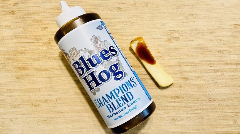 Bottle of Blues Hog Smokey Mountain BBQ Sauce with sauced steak fry