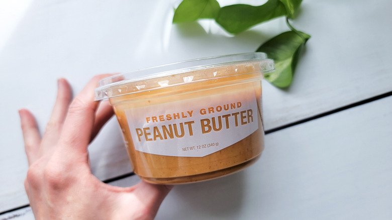 handing holding peanut butter tub