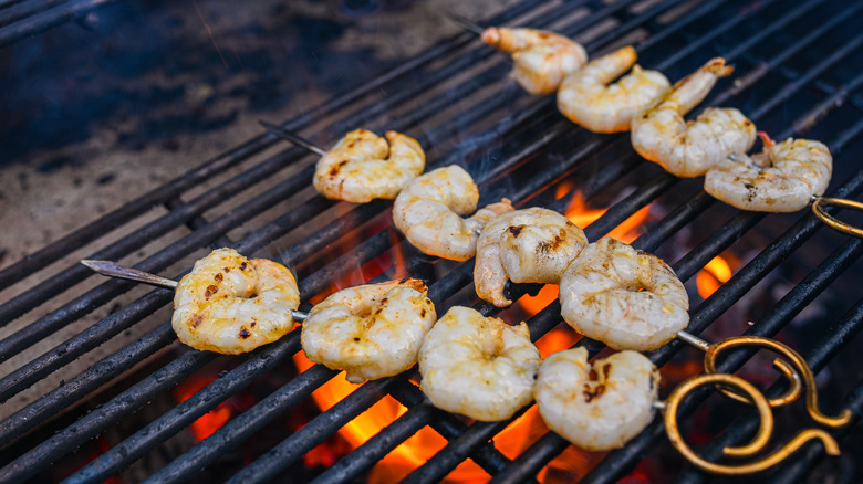 Shrimp skewers on the grill with flames