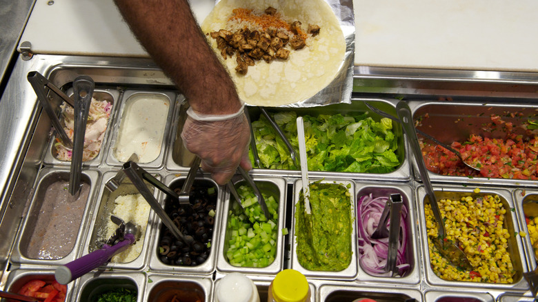 gloved hand making burrito