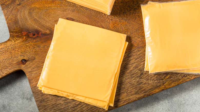 Slices of American cheese on a cutting board