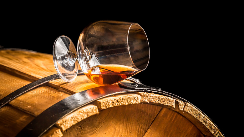 Glass of cognac on barrel