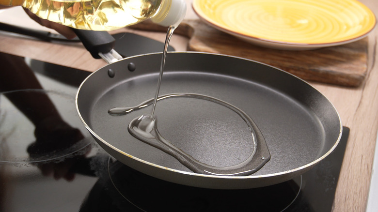 Adding oil to a frying pan